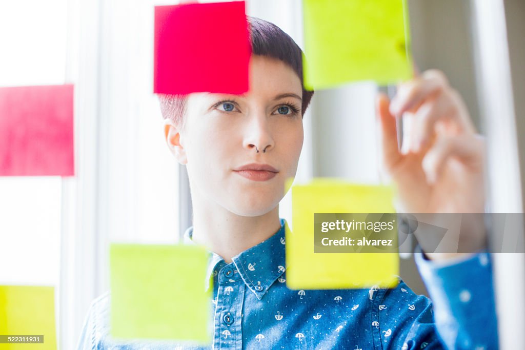 Attractive young woman viewing post-it notes