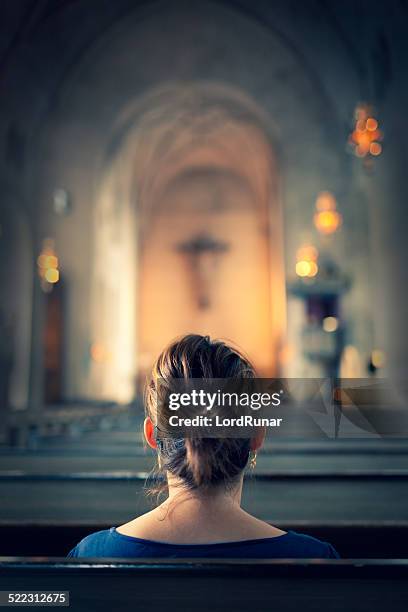 woman visiting a christian church - katholicisme stockfoto's en -beelden