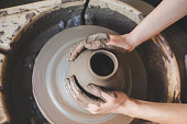 Hands working on pottery wheel