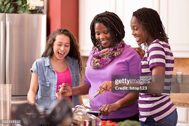 multi-ethnic family at home cooking together in kitchen. - adoption stock pictures, royalty-free photos & images