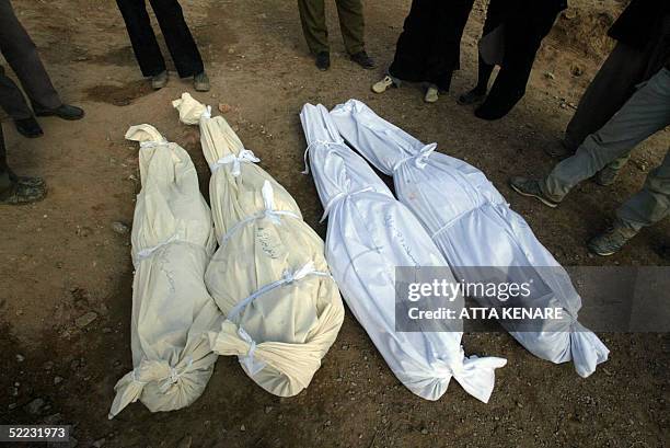 IOranians stand around the corpses of their relatives in Beheshte Zahra cemetery in Zarand 23 February 2005, after a powerful earthquake left...