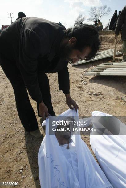 An Iranian man identifies the corpse of a relative in Beheshte Zahra cemetery in Zarand 23 February 2005, after a powerful earthquake left hundreds...