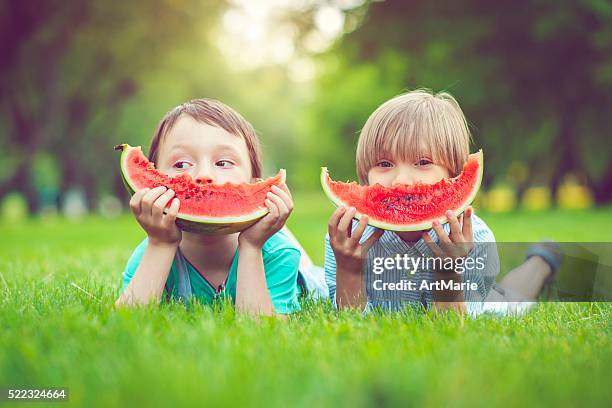 friends in summer - child eating a fruit stock pictures, royalty-free photos & images