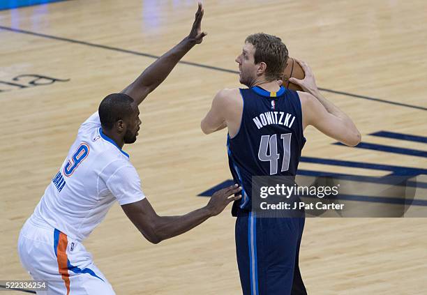 Dirk Nowitzki of the Dallas Mavericks looks to pass the ball as Serge Ibaka of the Oklahoma City Thunder applies pressure during the first half of...
