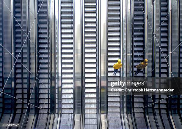 person on moving escalator - rolltreppe von oben stock-fotos und bilder