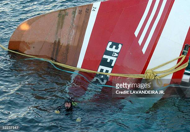 Diver swims next to the remains of the ship "Siempre Cansina" at the coast of Vivero, northwestern Spain, 24 February 2005. The bodies of fourdead...
