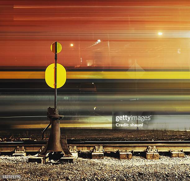 passing freight train - train yard at night stock pictures, royalty-free photos & images