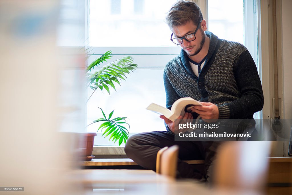 Hombre leyendo en la biblioteca
