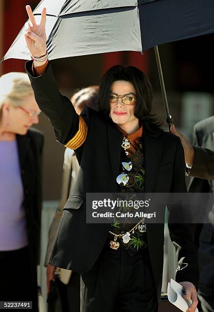 Singer Michael Jackson flashes a "V" sign to fans as he departs the Santa Barbara County Courthouse following the jury selection phase of his child...