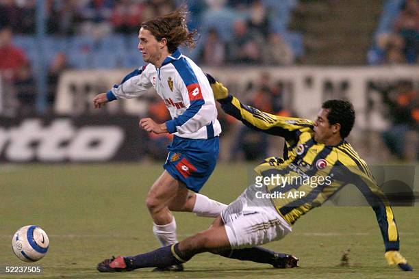 Zaragoza's Savio is tackled by Fenerbahce's Nobre Marcio during their UEFA Cup in their third round matches in Zaragoza, 24 February 2005. AFP PHOTO/...