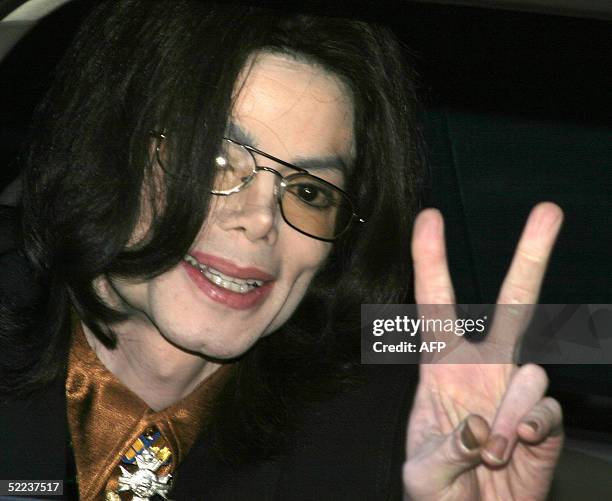 Pop star Michael Jackson makes a peace sign from the window of his car as he leaves Santa Barbara County Superior Court 24 February 2005 in Santa...