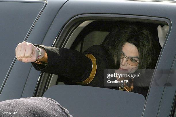 Pop star Michael Jackson punches his fist from the window of his car as he leaves 24 February 2005 Santa Barbara County Superior Court in Santa...