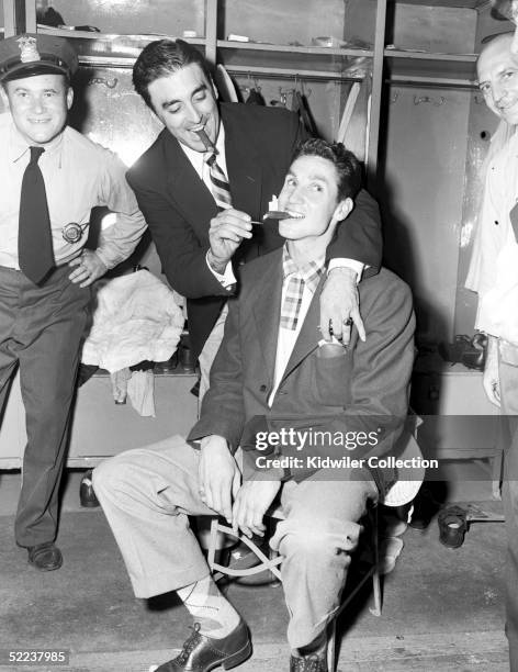 Pitcher Sal Maglie lights the postgame cigar of outfielder Bobby Thomson of the New York Giants after the deciding game 3 for the National League...