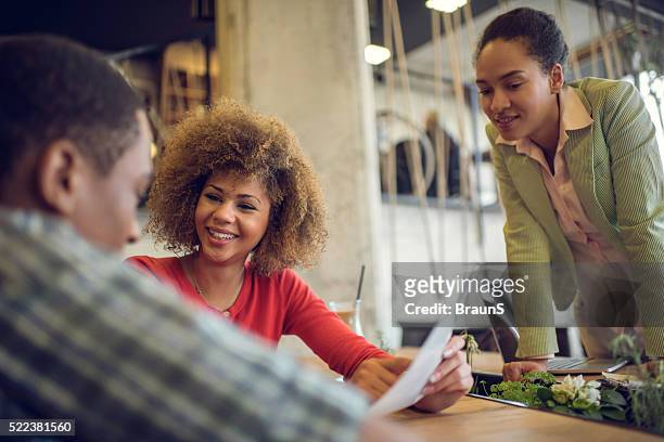 african american start up team working on reports at office. - red dress shirt stock pictures, royalty-free photos & images