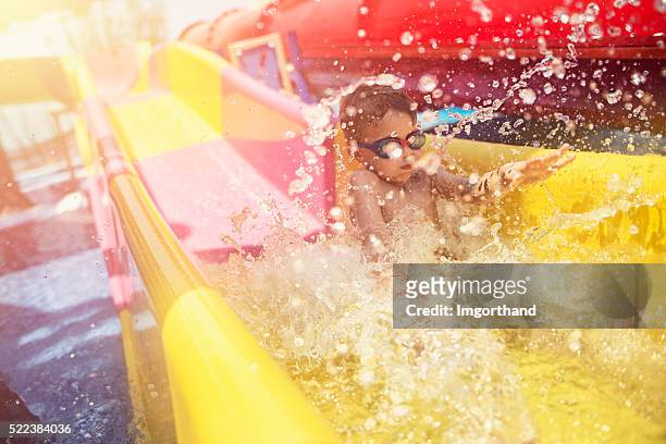 little boy having fun sliding in water park - waterslide bildbanksfoton och bilder