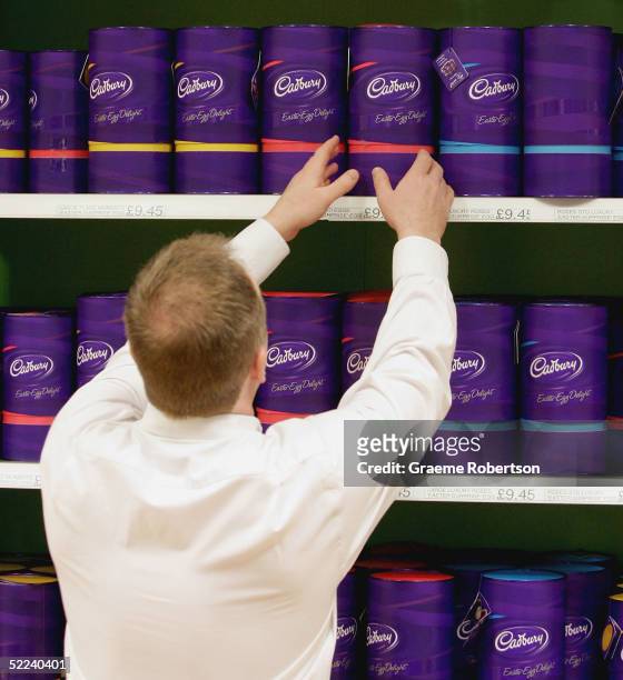 Man lifts a Cadbury Chocolate easter egg from the shelf at the Cadbury World visitor centre on February 25, 2005 in Birmingham, England. The company...