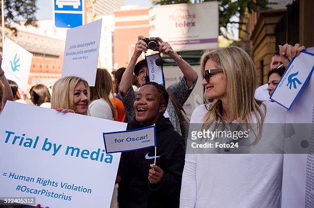 Convicted murderer Oscar Pistorius supporters carry posters outside court during his appearance for a postponement of his sentencing hearing at the...