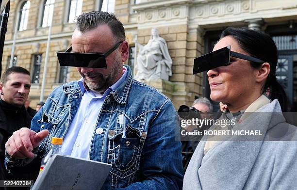 Lutz Bachmann , founder of Germany's xenophobic and anti-Islamic PEGIDA movement , and his wife Vicky Bachmann have their eyes covered as if...