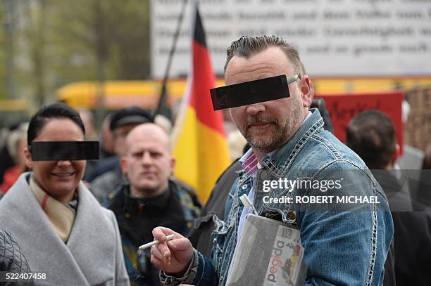 Lutz Bachmann, founder of Germany's xenophobic and anti-Islamic PEGIDA movement , and his wife Vicky Bachmann have their eyes covered as if pixelized...
