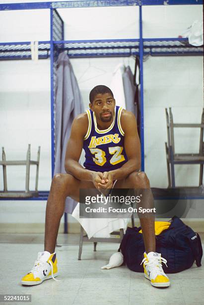 Los Angeles Lakers' guard Earvin "Magic" Johnson sits in a locker room in a circa 1980s photo.