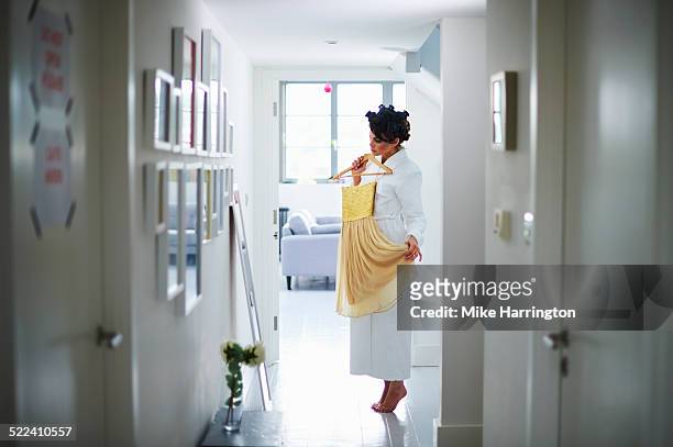 woman in robe choosing dress in front of mirror - choosing clothes stock pictures, royalty-free photos & images