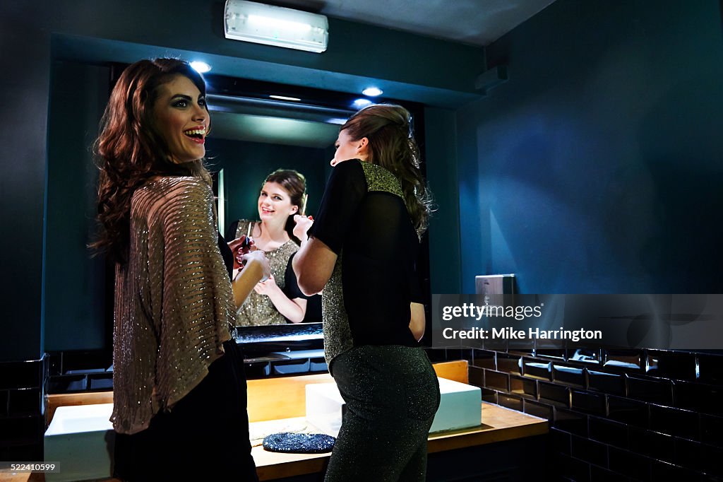 Women re-applying makeup in club toilets