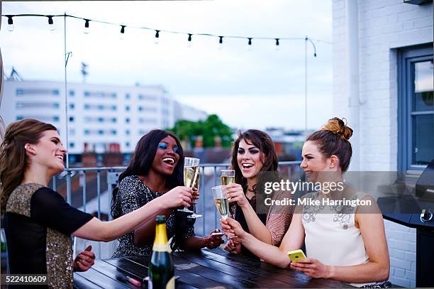 women drinking outside on urban rooftop garden. - champagne rooftop stock pictures, royalty-free photos & images