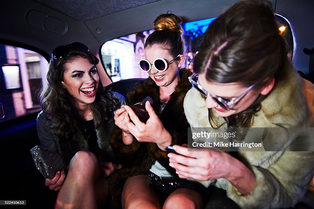Women laughing together in taxi