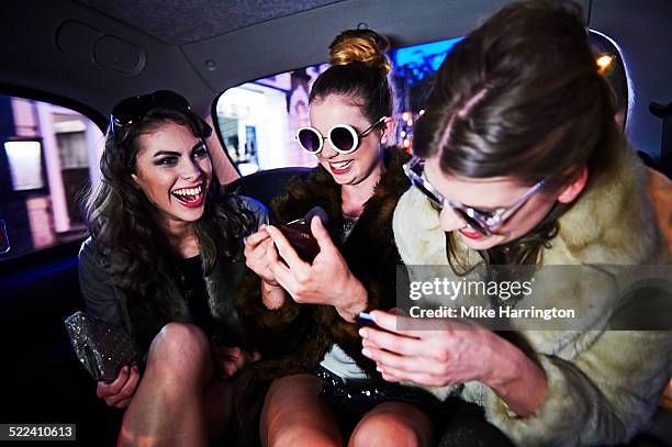 women laughing together in taxi - friends inside car imagens e fotografias de stock