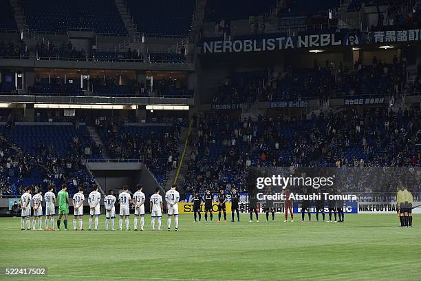 Players stand for a moment of silence for the victims of series of earthquakes in Kumamoto prior to the AFC Champions League Group G match between...