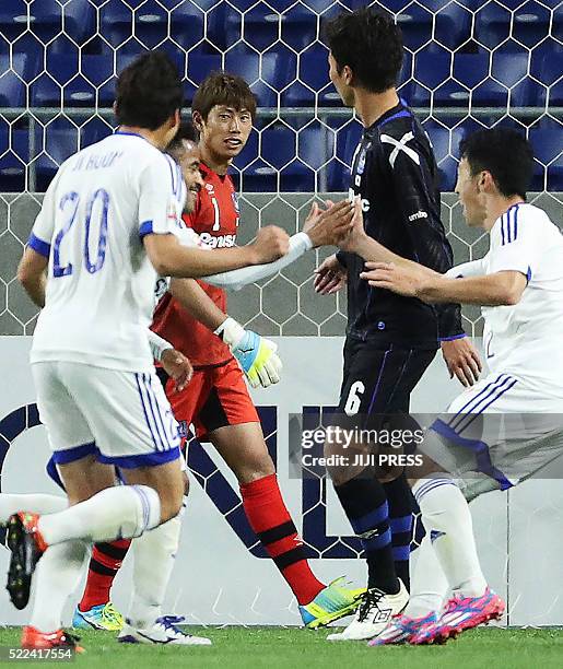 Japan's Gamba Osaka goalkeeper Masaaki Higashiguchi watches South Korea's Suwon Bluewings midfielder Santos celebrating his goal from a penalty kick...