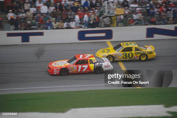 Darrell Waltrip drives his Tide car against the Michael Waltrip Country Time car during the Daytona 500 at the Daytona Speedway on February 19, 1989...