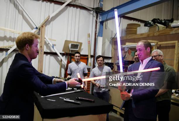 Britain's Prince Harry and Prince William, Duke of Cambridge try out light sabres during a tour of the Star Wars sets at Pinewood studios in Iver...