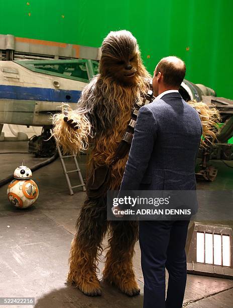 Britain's Prince William, Duke of Cambridge talks with Chewbacca during a tour of the Star Wars sets at Pinewood studios in Iver Heath, west of...