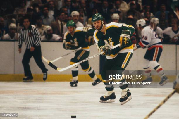 Minnesota North Stars' defenseman Brad Maxwell skates with the puck against the New York Islanders during a game at the Nassau Coliseum circa 1981 in...