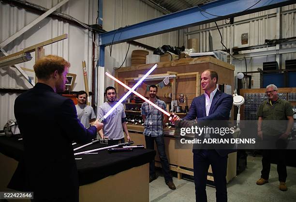 The Duke of Cambridge, Prince William tries a light sabre against his brother Prince Harry during a visit to the Star Wars film set at Pinewood...