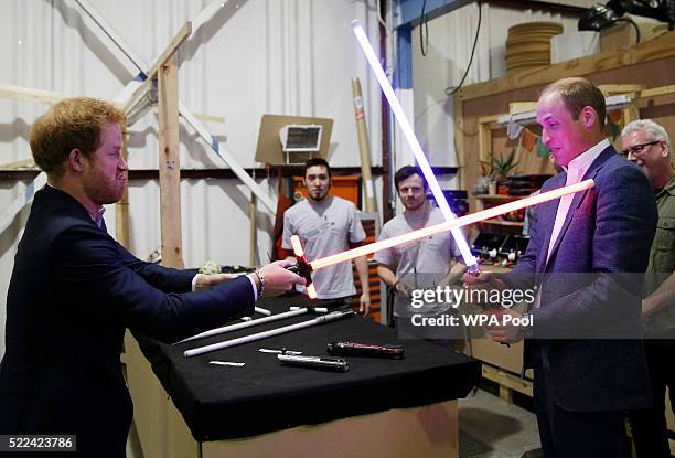 Prince Harry and Prince William, Duke of Cambridge try out light sabres during a tour of the Star Wars sets at Pinewood studios on April 19, 2016 in...