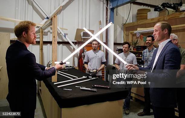 Prince Harry and Prince William, Duke of Cambridge try out light sabres during a tour of the Star Wars sets at Pinewood studios on April 19, 2016 in...