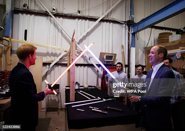 Prince Harry and Prince William, Duke of Cambridge try out light sabres during a tour of the Star Wars sets at Pinewood studios on April 19, 2016 in...