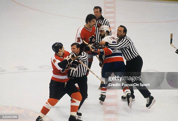 Referees try to break up a fight between New York Islanders' John Tonelli and Philadelphia Flyers' Andre "Moose" Dupont during a game at Nassau...