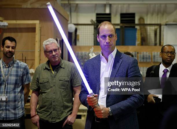Prince William, Duke of Cambridge holds a lightsaber during a tour of the Star Wars sets at Pinewood studios on April 19, 2016 in Iver Heath,...