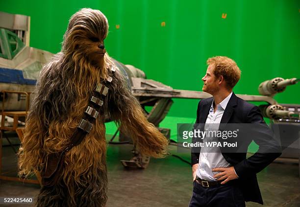 Prince Harry meets Chewbacca during a tour of the Star Wars sets at Pinewood studios on April 19, 2016 in Iver Heath, England. Prince William and...