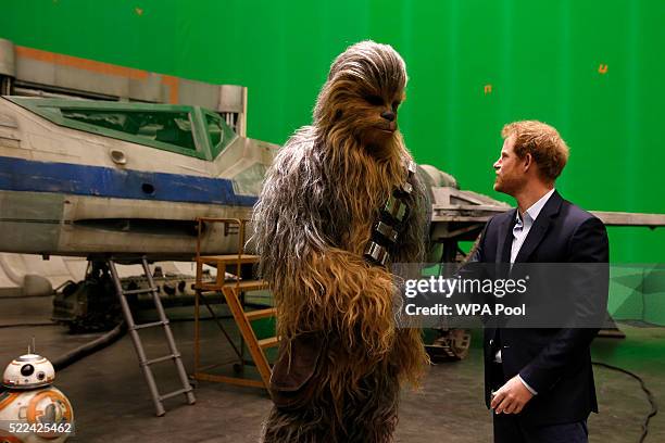 Prince Harry meets Chewbacca during a tour of the Star Wars sets at Pinewood studios on April 19, 2016 in Iver Heath, England. Prince William and...