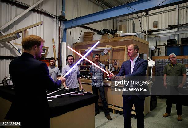 Prince Harry and Prince William, Duke of Cambridge try out light sabres during a tour of the Star Wars sets at Pinewood studios on April 19, 2016 in...