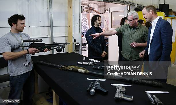 Britain's Prince William, Duke of Cambridge is shown props including Chewbacca's crossbow during a tour of the Star Wars sets at Pinewood studios in...