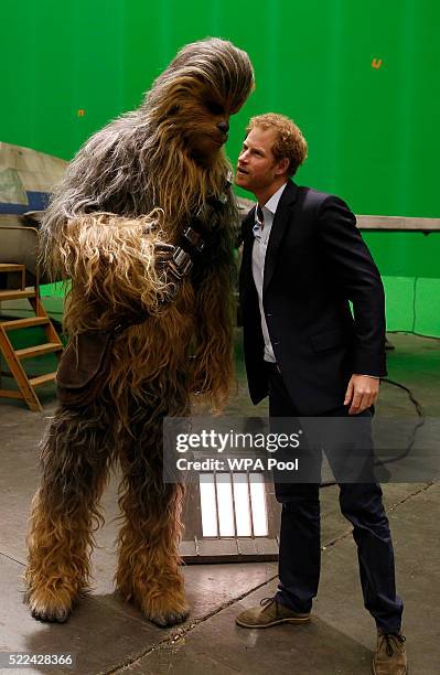 Prince Harry speaks with Chewbacca during a tour of the Star Wars sets at Pinewood studios on April 19, 2016 in Iver Heath, England. Prince William...