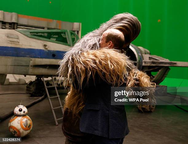 Prince William, Duke of Cambridge is hugged by Chewbacca during a tour of the Star Wars sets at Pinewood studios on April 19, 2016 in Iver Heath,...