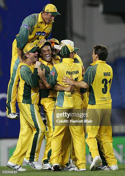 Mike Hussey of Australia comes over the top of his team's celebration of the run out of Hamish Marshall of New Zealand during the 3rd One Day...