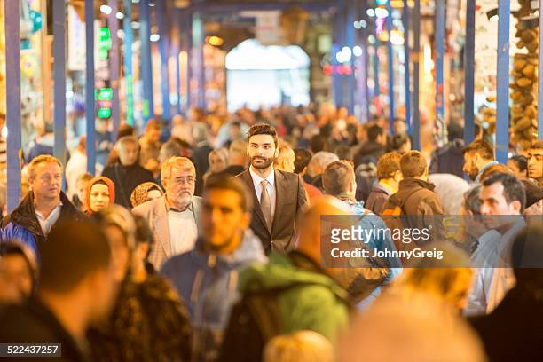 businessman walking through bazaar - shopping crowd stockfoto's en -beelden