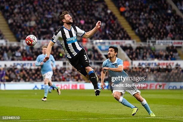 Paul Dummett of Newcastle United heads the ball clear of Jesus Navas of Manchester City during the Barclays Premier League match between Newcastle...